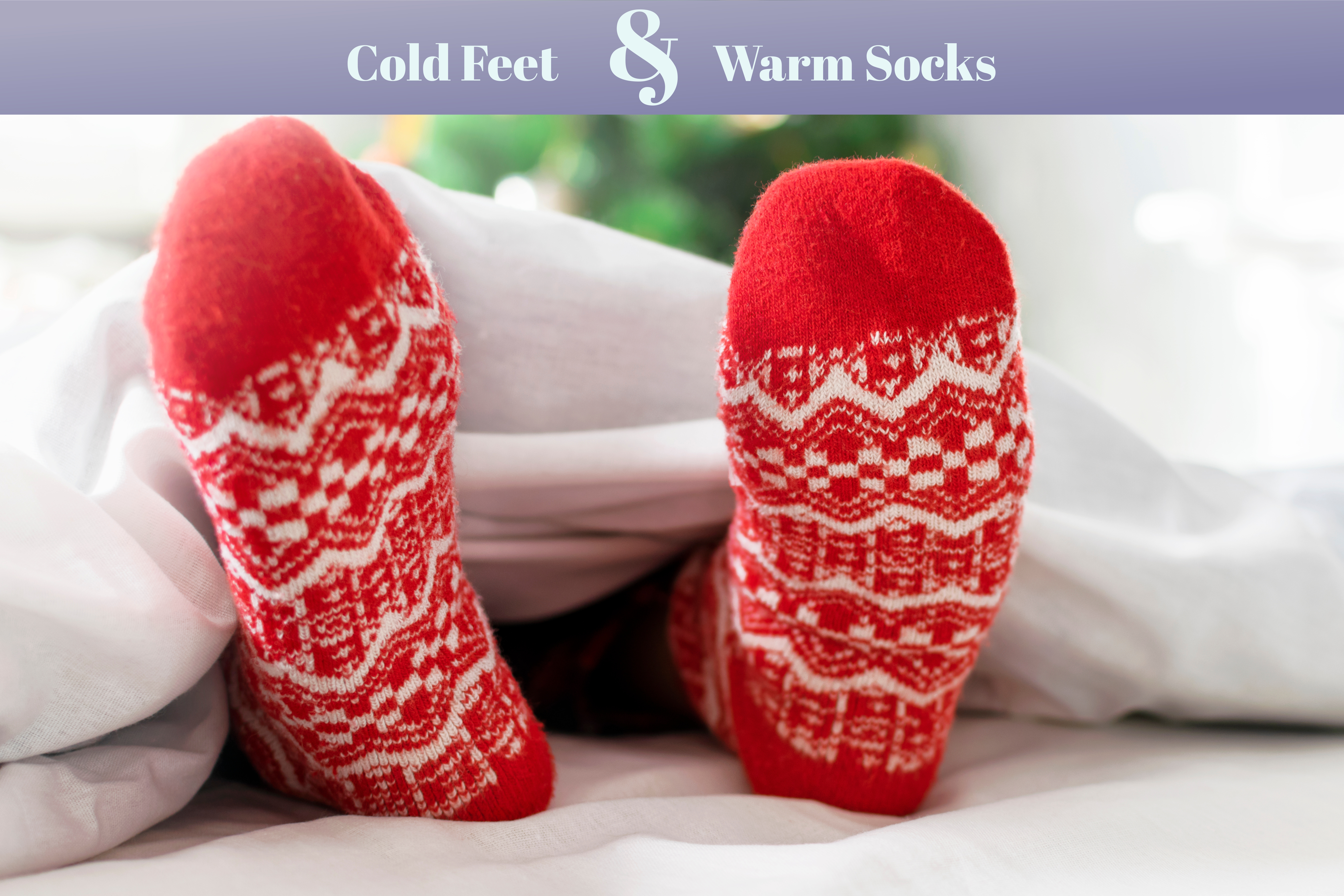 Feet wearing red socks sticking out from under white blanket